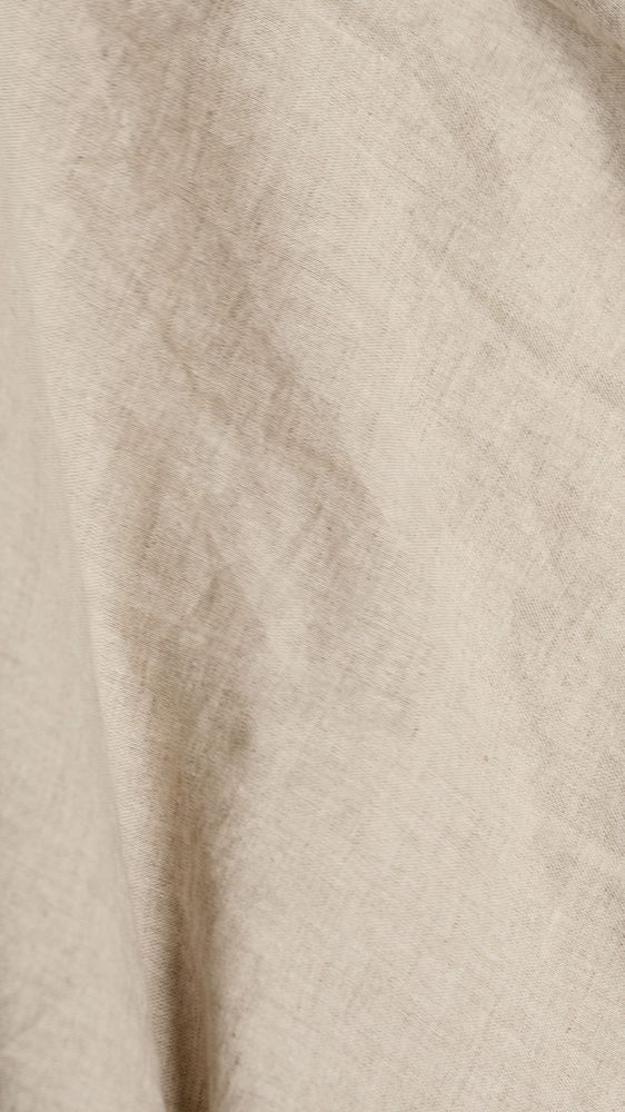 Détail des plis et du tissage d’une étoffe de lin beige.